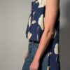 Vintage lange mouwloze blouse in diepblauw met grote bloemenprint in crème en opvallende paarse knopen.