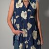 Vintage lange mouwloze blouse in diepblauw met grote bloemenprint in crème en opvallende paarse knopen.