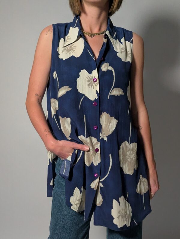 Vintage lange mouwloze blouse in diepblauw met grote bloemenprint in crème en opvallende paarse knopen.