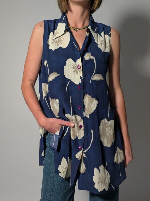 Vintage lange mouwloze blouse in diepblauw met grote bloemenprint in crème en opvallende paarse knopen.