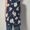 Vintage lange mouwloze blouse in diepblauw met grote bloemenprint in crème en opvallende paarse knopen.