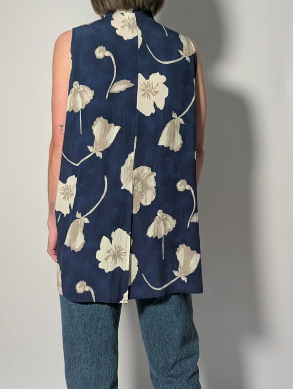 Vintage lange mouwloze blouse in diepblauw met grote bloemenprint in crème en opvallende paarse knopen.