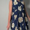 Vintage lange mouwloze blouse in diepblauw met grote bloemenprint in crème en opvallende paarse knopen.