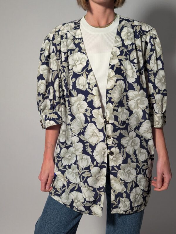 Vintage openvallend jasje in diepblauw met grote bloemenprint in crème en grijsgroene tinten.