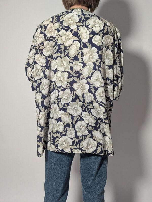 Vintage openvallend jasje in diepblauw met grote bloemenprint in crème en grijsgroene tinten.