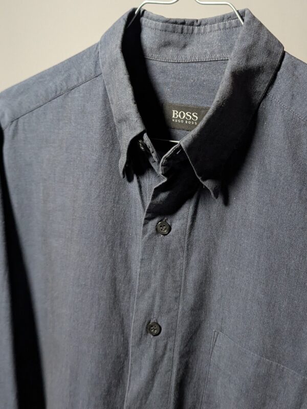 Vintage Hugo Boss blouse in blauwgrijze tint met lange mouwen, borstzak en relaxte pasvorm.