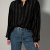 Vintage zwarte blouse met lange mouwen en subtiele verticale strepen in een fijn contrasterend patroon.