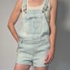 Vintage lichtblauwe denim playsuit met verstelbare schouderbanden, korte broekspijpen en relaxte pasvorm.