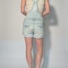 Vintage lichtblauwe denim playsuit met verstelbare schouderbanden, korte broekspijpen en relaxte pasvorm.