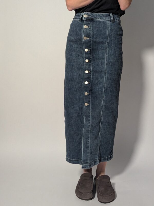 Vintage denim midi rok met hoge taille, rechte pasvorm en asymmetrische knoopsluiting aan de voorkant in mediumblauwe wassing.