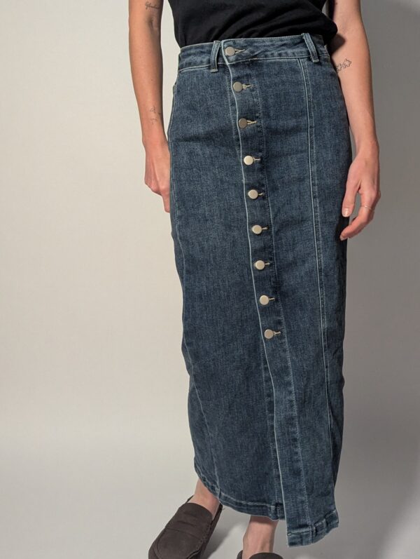 Vintage denim midi rok met hoge taille, rechte pasvorm en asymmetrische knoopsluiting aan de voorkant in mediumblauwe wassing.