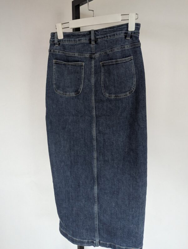 Vintage denim midi rok met hoge taille, rechte pasvorm en asymmetrische knoopsluiting aan de voorkant in mediumblauwe wassing.