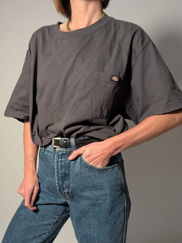 Vintage Dickies T-shirt in vaal zwart met korte mouwen, borstzak en subtiel logo detail.