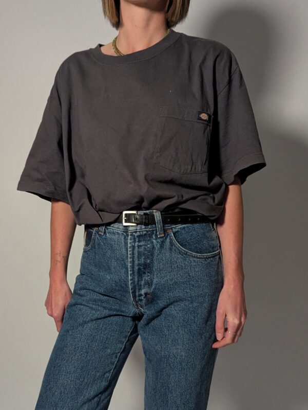Vintage Dickies T-shirt in vaal zwart met korte mouwen, borstzak en subtiel logo detail.