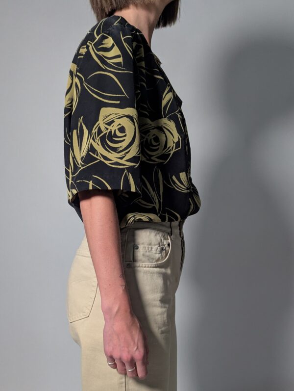 Vintage zwarte blouse met korte mouwen en abstracte rozenprint in olijfgroene tinten.