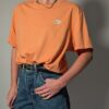 Vintage Nike T-shirt in zachte perziktint met korte mouwen, relaxte pasvorm en subtiel wit logo op de borst.