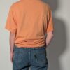 Vintage Nike T-shirt in zachte perziktint met korte mouwen, relaxte pasvorm en subtiel wit logo op de borst.