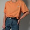 Vintage Nike T-shirt in zachte perziktint met korte mouwen, relaxte pasvorm en subtiel wit logo op de borst.