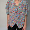 Vintage blouse met korte pofmouwen en kleurrijke bloemenprint in blauw, rood, geel en groentinten.