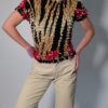 Vintage popcorn top in goud, zwart en rood met geplooide stretchstructuur en korte mouwen.