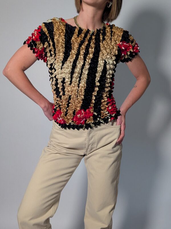 Vintage popcorn top in goud, zwart en rood met geplooide stretchstructuur en korte mouwen.