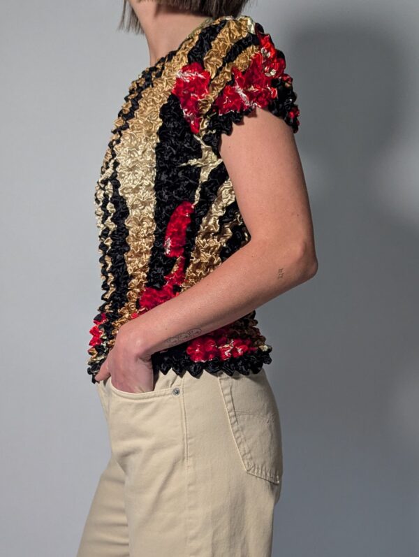Vintage popcorn top in goud, zwart en rood met geplooide stretchstructuur en korte mouwen.