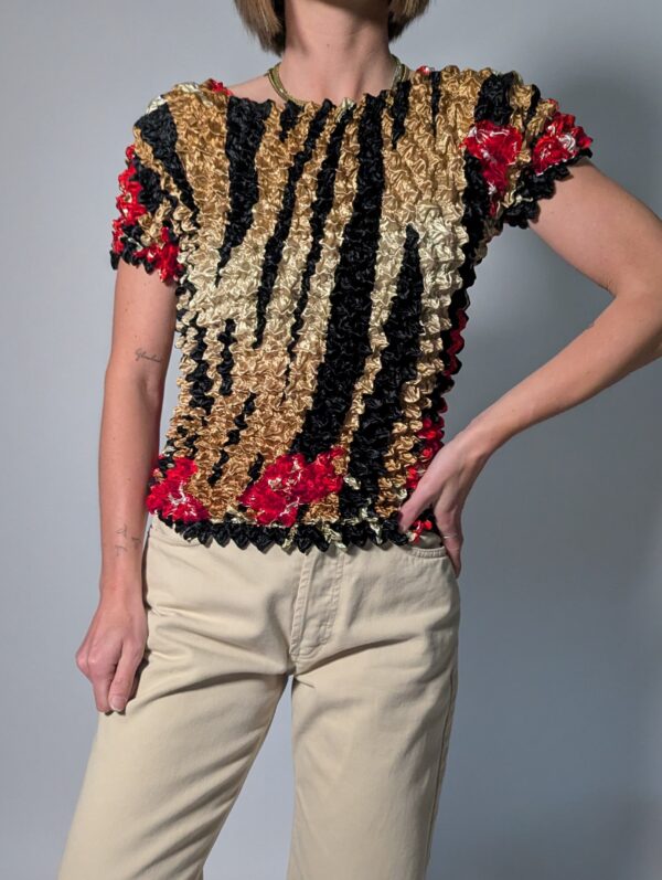 Vintage popcorn top in goud, zwart en rood met geplooide stretchstructuur en korte mouwen.