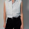 Vintage lichtblauwe mouwloze blouse met geborduurde bloemen, kraag en knoopsluiting.