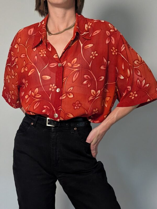 Vintage roestrode blouse met korte mouwen en fijne florale print in zachte perzik- en zandtinten.