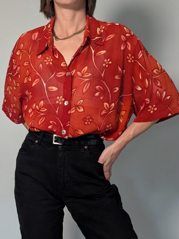 Vintage roestrode blouse met korte mouwen en fijne florale print in zachte perzik- en zandtinten.