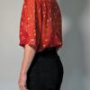 Vintage roestrode blouse met korte mouwen en fijne florale print in zachte perzik- en zandtinten.