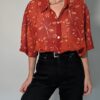 Vintage roestrode blouse met korte mouwen en fijne florale print in zachte perzik- en zandtinten.