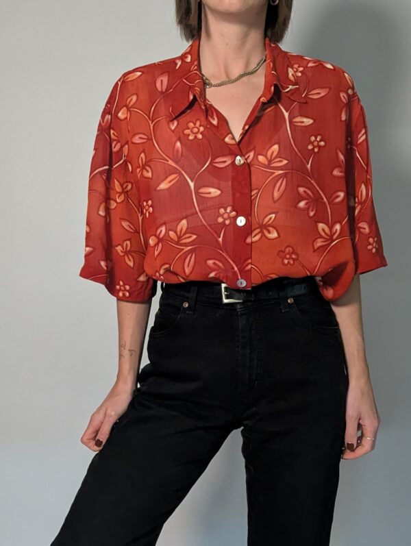 Vintage roestrode blouse met korte mouwen en fijne florale print in zachte perzik- en zandtinten.