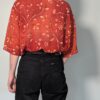 Vintage roestrode blouse met korte mouwen en fijne florale print in zachte perzik- en zandtinten.