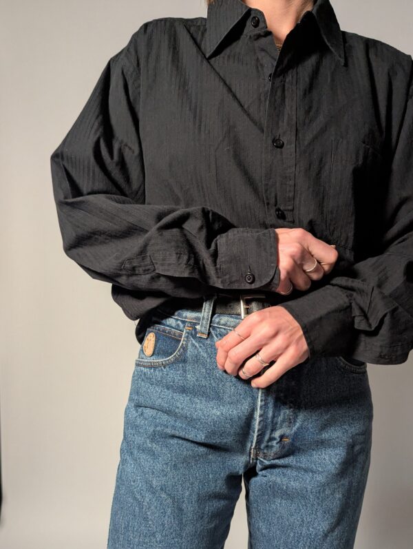 Vintage blouse in vaal zwarte tint met lange mouwen, subtiele structuur en relaxte pasvorm.