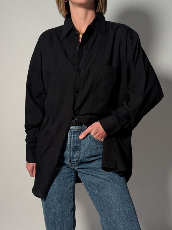 Vintage blouse in vaal zwarte tint met lange mouwen, subtiele structuur en relaxte pasvorm.