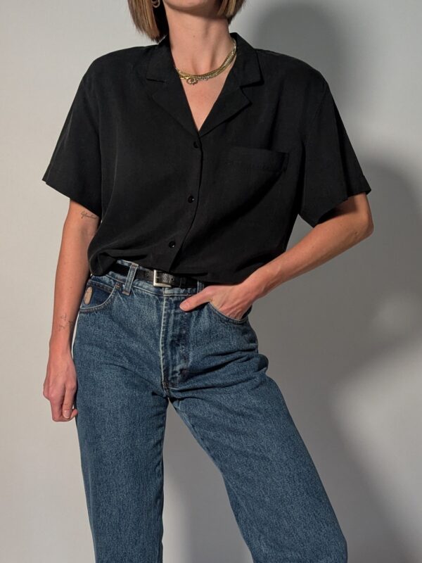 Vintage donkergrijze/zwarte blouse van 100% zijde met korte mouwen, borstzak en relaxte pasvorm.