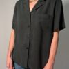 Vintage donkergrijze/zwarte blouse van 100% zijde met korte mouwen, borstzak en relaxte pasvorm.