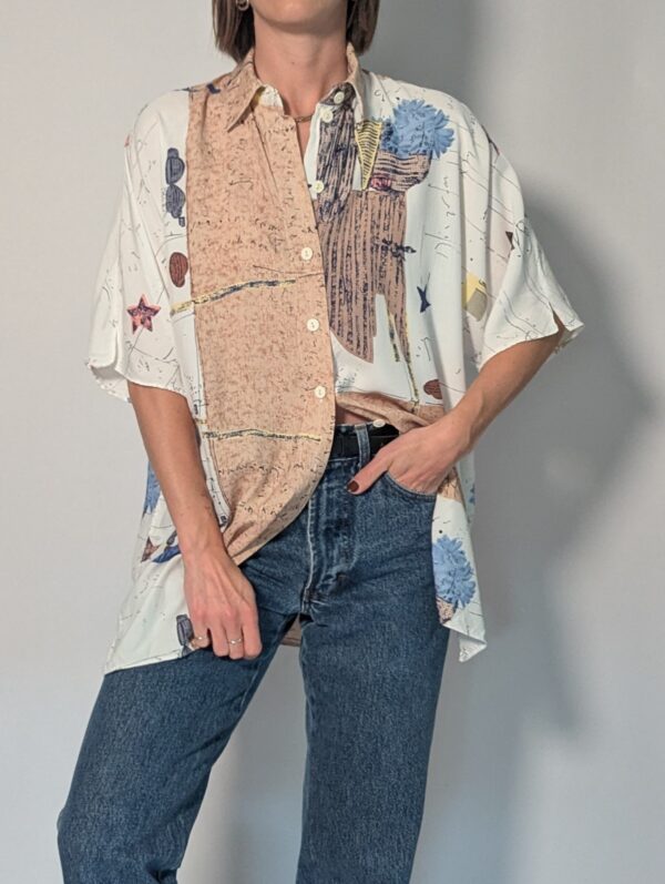 Vintage blouse met korte mouwen in crème, beige en blauw met abstracte bloemenprint en losse pasvorm.