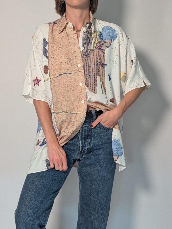 Vintage blouse met korte mouwen in crème, beige en blauw met abstracte bloemenprint en losse pasvorm.