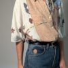 Vintage blouse met korte mouwen in crème, beige en blauw met abstracte bloemenprint en losse pasvorm.