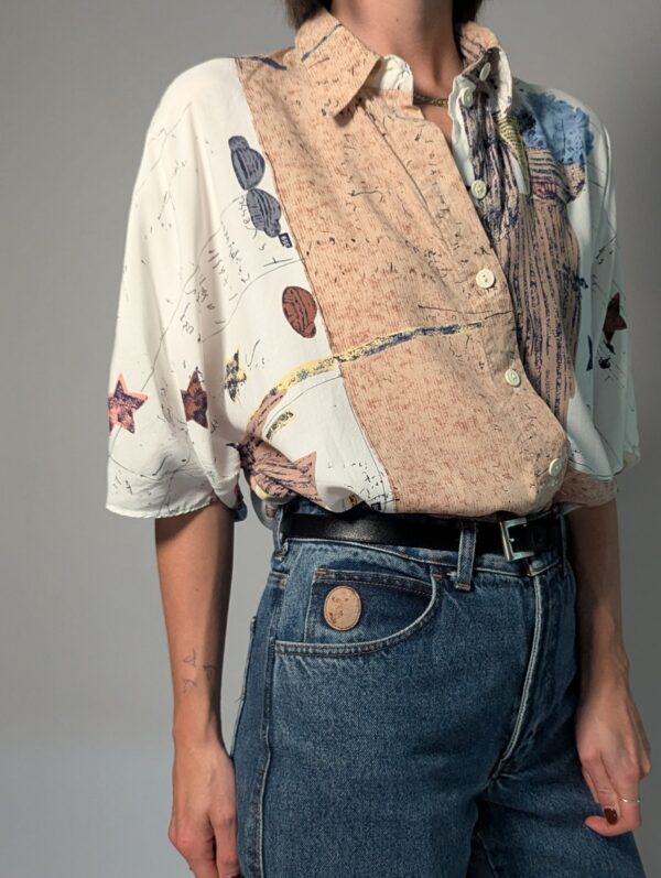 Vintage blouse met korte mouwen in crème, beige en blauw met abstracte bloemenprint en losse pasvorm.