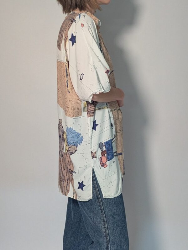 Vintage blouse met korte mouwen in crème, beige en blauw met abstracte bloemenprint en losse pasvorm.
