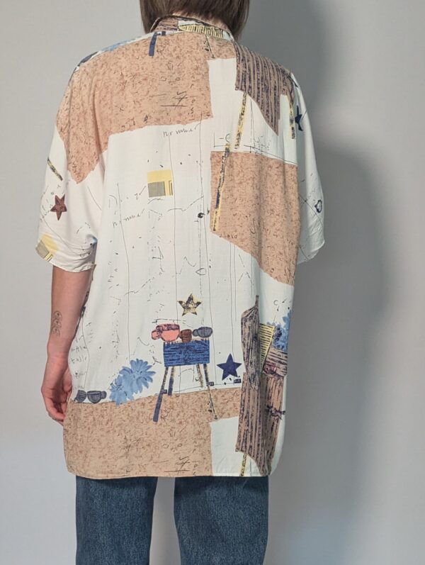 Vintage blouse met korte mouwen in crème, beige en blauw met abstracte bloemenprint en losse pasvorm.