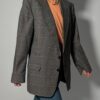 Vintage blazer in grijsbruine tint met subtiele plaid ruit, fijne krijtstreep en rechte oversized pasvorm.
