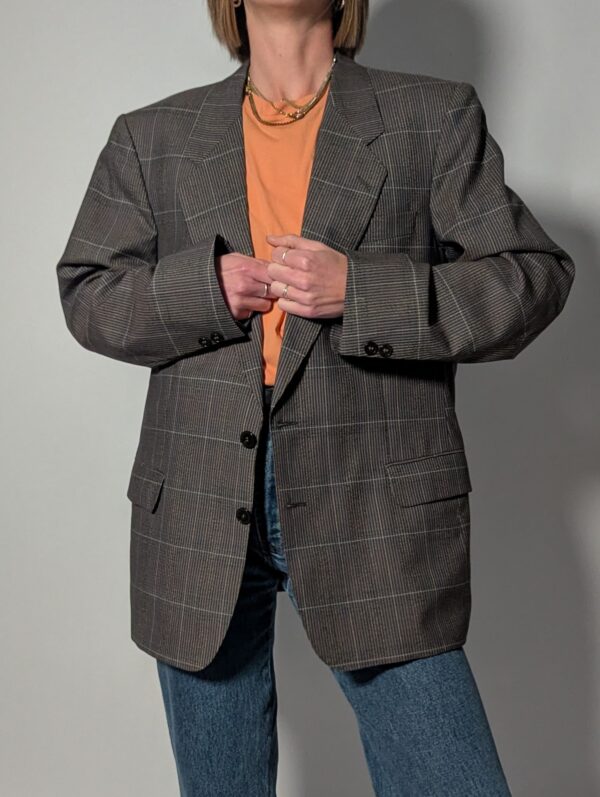 Vintage blazer in grijsbruine tint met subtiele plaid ruit, fijne krijtstreep en rechte oversized pasvorm.