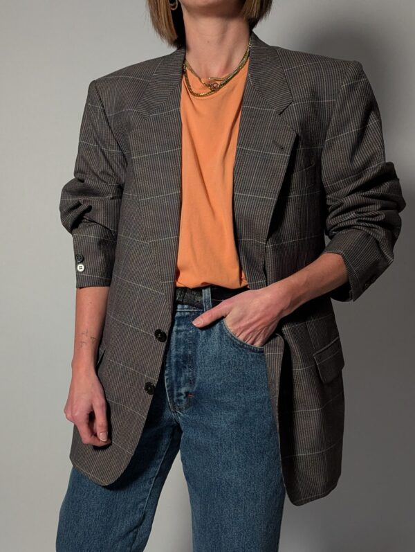 Vintage blazer in grijsbruine tint met subtiele plaid ruit, fijne krijtstreep en rechte oversized pasvorm.