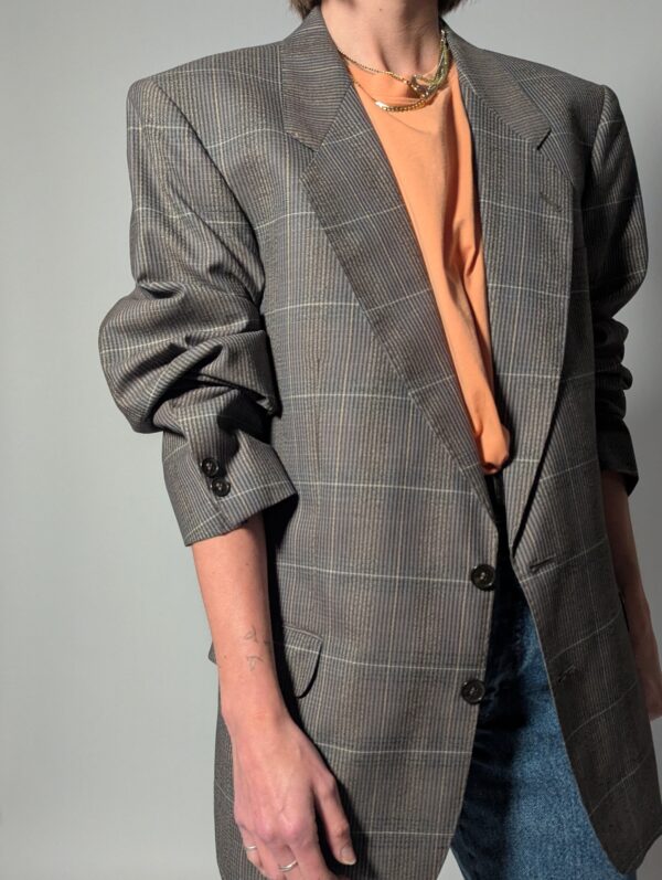 Vintage blazer in grijsbruine tint met subtiele plaid ruit, fijne krijtstreep en rechte oversized pasvorm.