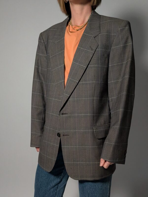 Vintage blazer in grijsbruine tint met subtiele plaid ruit, fijne krijtstreep en rechte oversized pasvorm.