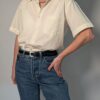 Vintage crèmekleurige blouse met korte mouwen, borstzak en luchtige pasvorm.